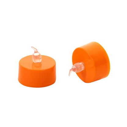 A 12-pack of orange flameless LED tea lights glowing with a warm flickering light on a festive autumn tabletop.