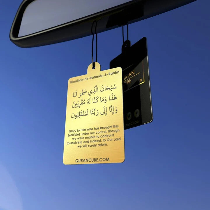 Quran Cube Oud fragrance hanging car air freshener card printed with Arabic Safar Dua script suspended against a dark car dashboard interior.