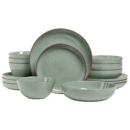 Over & Back 16 piece stoneware dinnerware set in light grey stacked neatly on a rustic wooden dining table
