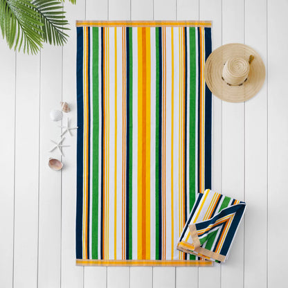 Flat lay view of the plush 500 GSM oversized 100 percent cotton jacquard beach towel spread out on golden sand.