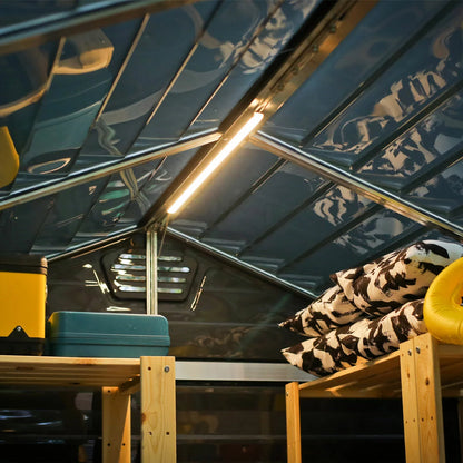 Palram Canopia LED Lighting System installed under a patio canopy, providing warm, ambient light for an evening outdoor garden setting.