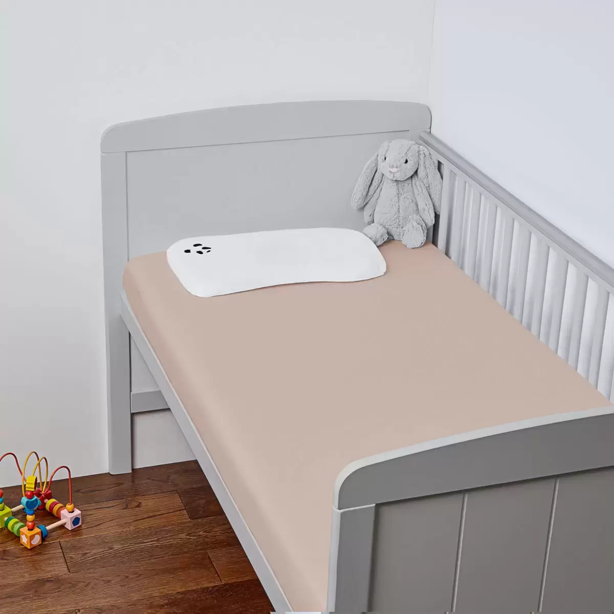 Close-up of the secure elasticated corner stitching on a white Panda bamboo fitted crib sheet.