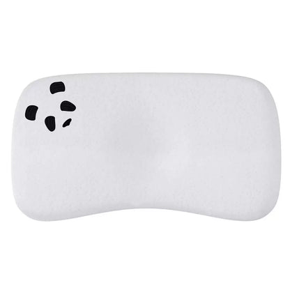 Soft white contoured Panda baby memory foam pillow featuring a silky bamboo fabric cover placed inside a modern nursery crib.