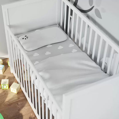 Soft white contoured Panda baby memory foam pillow featuring a silky bamboo fabric cover placed inside a modern nursery crib.