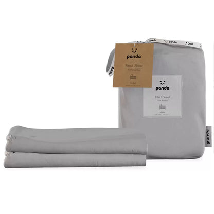 A close-up view of two folded Panda bamboo cot fitted sheets showing the silky, organic knit texture in a soft nursery setting.