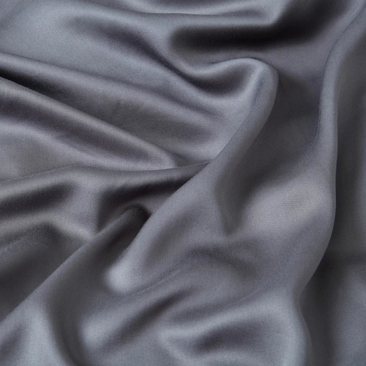 Dark grey Panda double bamboo flat sheet draped smoothly over a modern bed frame highlighting its silky texture and rich charcoal sheen.