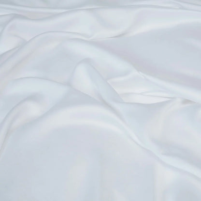 Crisp white Panda 100 percent bamboo flat sheet folded neatly on a bed showing its silky texture and natural luster.