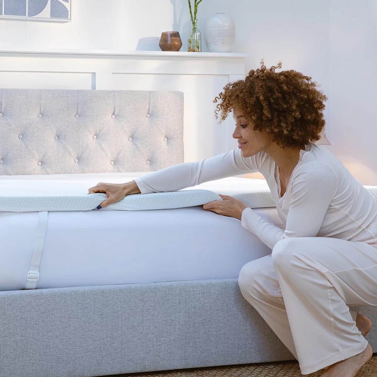 Corner view of the white Panda Memory Foam Bamboo Mattress Topper showing its textured bamboo zip cover, black anti-slip base, and elastic corner strap on a modern bed.