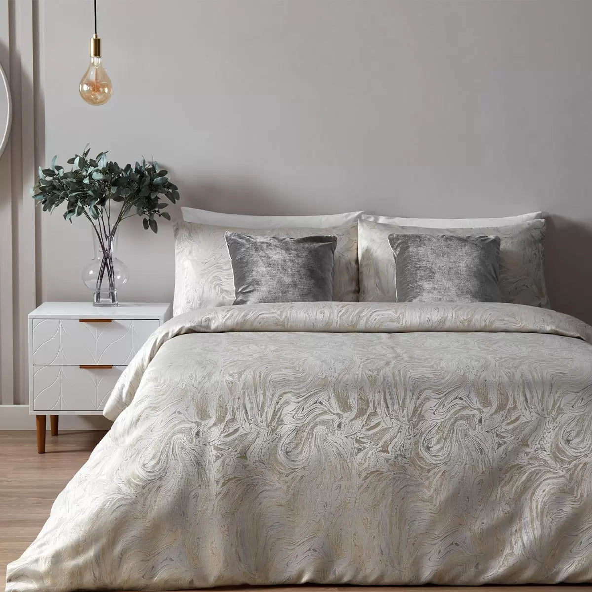Neutral oyster Paoletti duvet cover displaying a metallic marble pattern on a bed with two matching pillowcases.