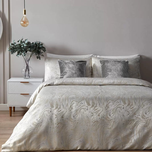 Neutral oyster Paoletti duvet cover displaying a metallic marble pattern on a bed with two matching pillowcases.