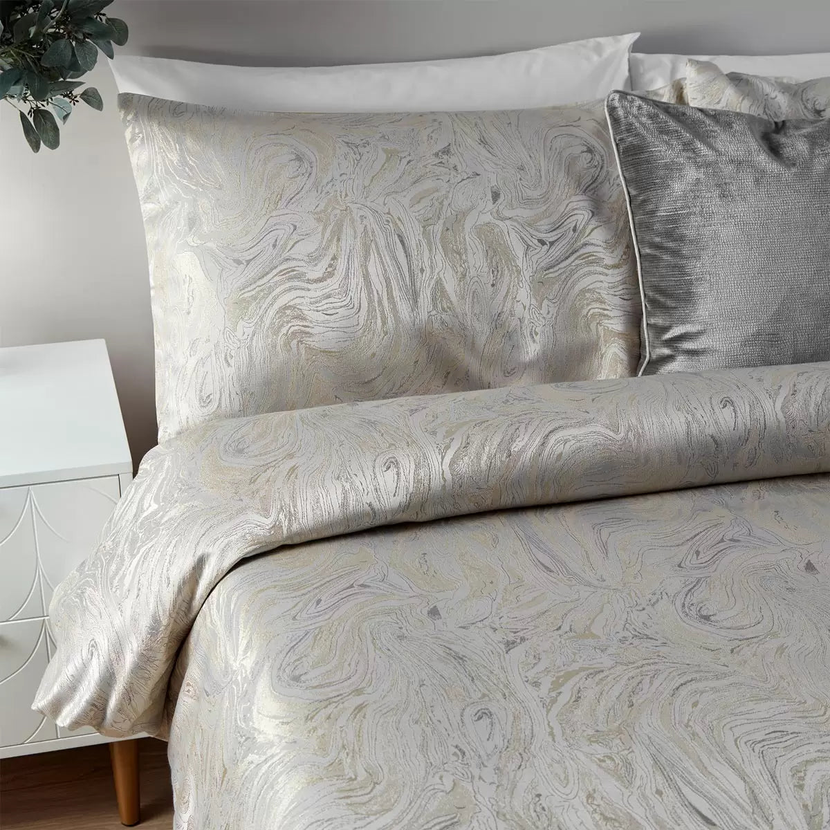 Neutral oyster Paoletti duvet cover displaying a metallic marble pattern on a bed with two matching pillowcases.
