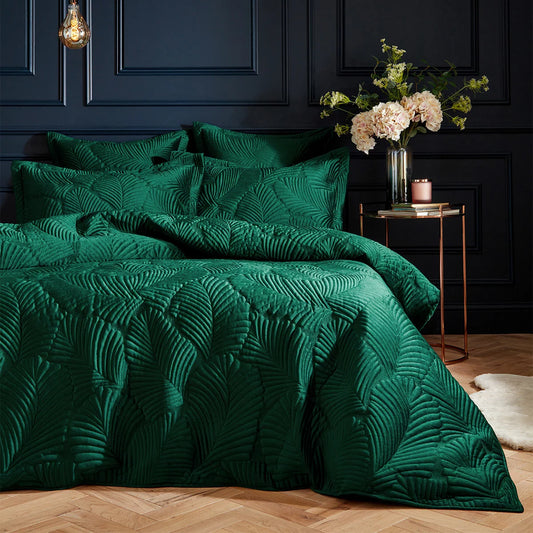 Rich emerald green Paoletti velvet duvet cover with detailed palm embroidery and matching Oxford pillowcases set on a bed.