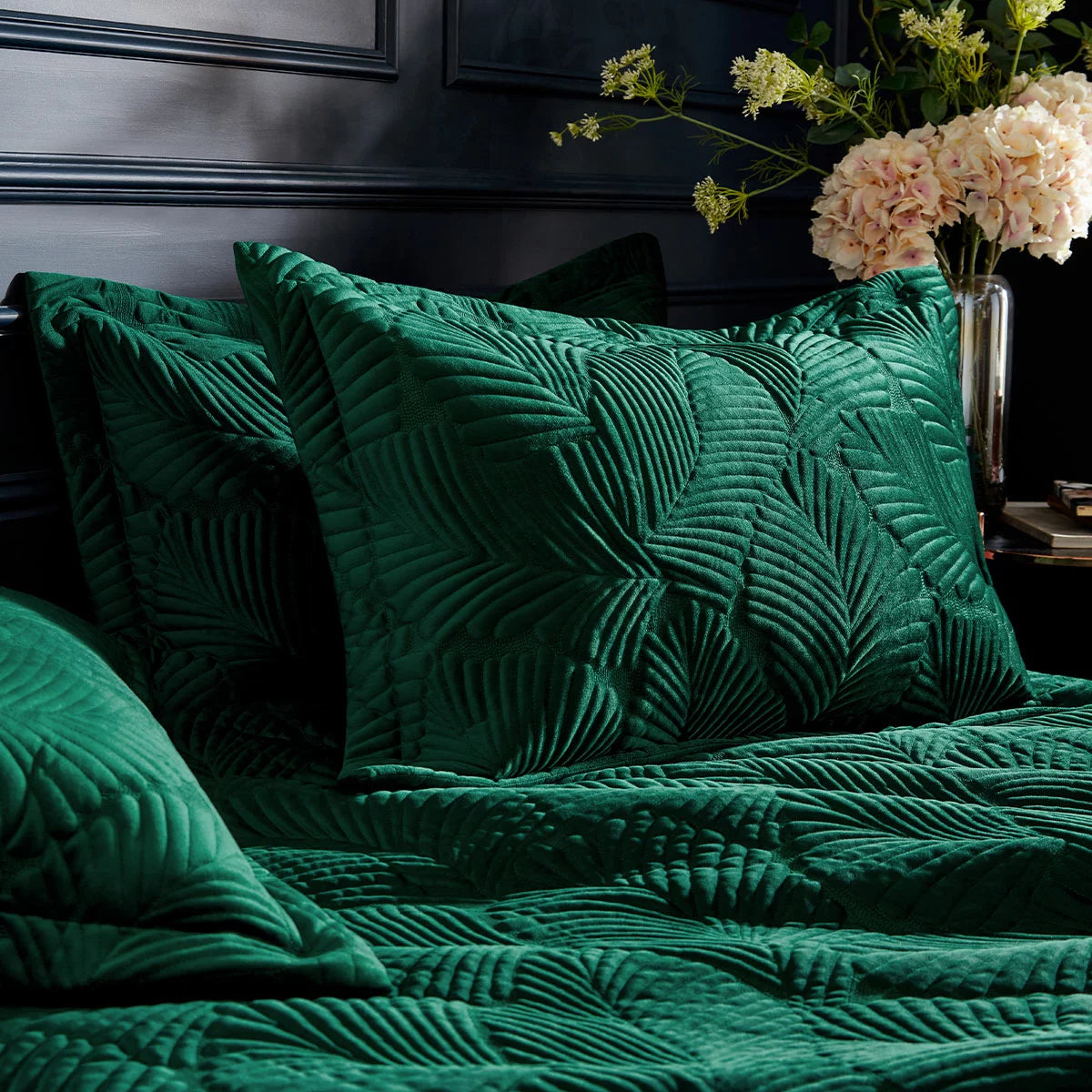 Rich emerald green Paoletti velvet duvet cover with detailed palm embroidery and matching Oxford pillowcases set on a bed.