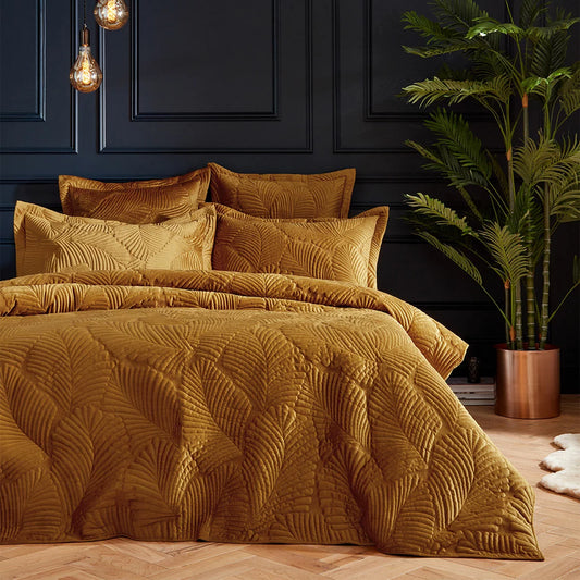 Rich gold Paoletti velvet duvet cover featuring intricate palm embroidery with matching Oxford pillowcases arranged on a bed.