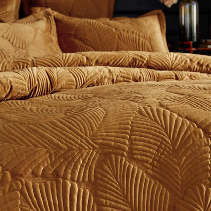 Rich gold Paoletti velvet duvet cover featuring intricate palm embroidery with matching Oxford pillowcases arranged on a bed.