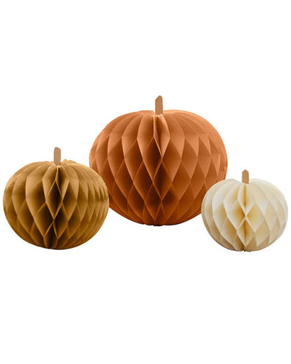 Three colorful paper pumpkin honeycomb decorations in four, five, and seven-inch sizes displaying magnetic closures on a wooden table.