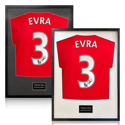 A professionally framed Manchester United football shirt signed by Patrice Evra, centered within a deep-set frame featuring a crisp white mount board against a neutral wall.