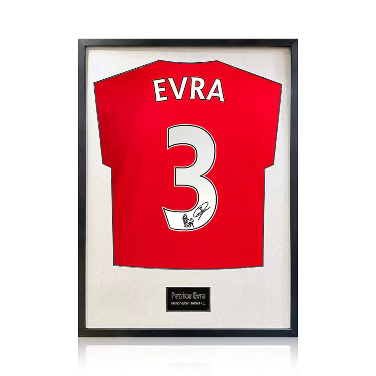 A professionally framed Manchester United football shirt signed by Patrice Evra, centered within a deep-set frame featuring a crisp white mount board against a neutral wall.