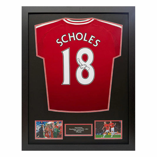 A professionally framed 2024/25 Manchester United football shirt hand-signed by Paul Scholes, displayed in a premium wooden frame against a neutral wall.