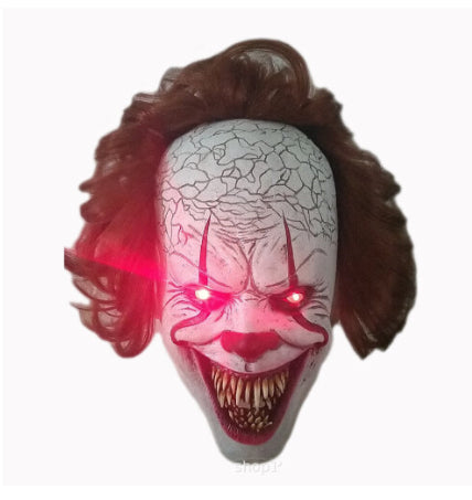 Front view of the adult Pennywise IT clown latex mask featuring realistic white face paint, creepy red smile lines, and bright red synthetic hair.