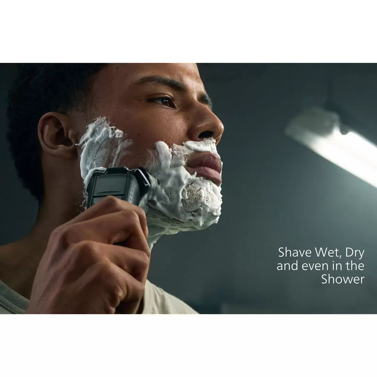 Philips Series 5000 electric shaver in a metallic finish, displayed with its nose trimmer accessory and travel case on a clean bathroom shelf.