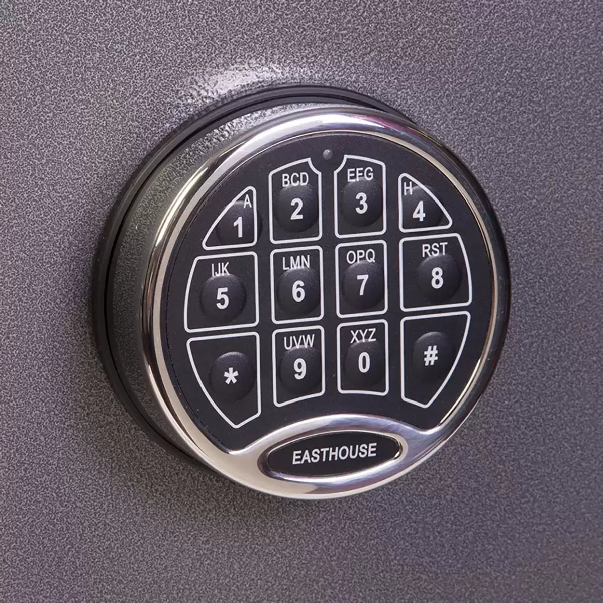 Dark metallic graphite steel deposit safe featuring a front-loading drawer handle above a digital electronic keypad, positioned on a solid concrete retail back-office floor.