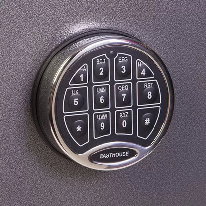 Dark metallic graphite steel deposit safe featuring a front-loading drawer handle above a digital electronic keypad, positioned on a solid concrete retail back-office floor.