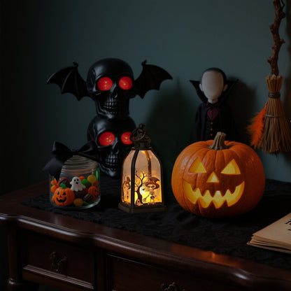 A portable black plastic Halloween handheld lantern glowing warmly with spooky pumpkin and skull pattern designs on a festive party table.