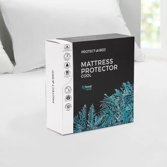 White Protect-A-Bed Tencel Cool Mattress Protector fitted smoothly over a thick mattress in a bright bedroom setting.