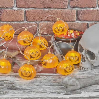 A 1.5-meter string of 10 pumpkin LED lights glowing warmly on a dark indoor party wall.