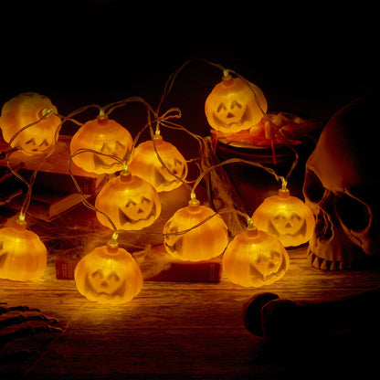 A 1.5-meter string of 10 pumpkin LED lights glowing warmly on a dark indoor party wall.