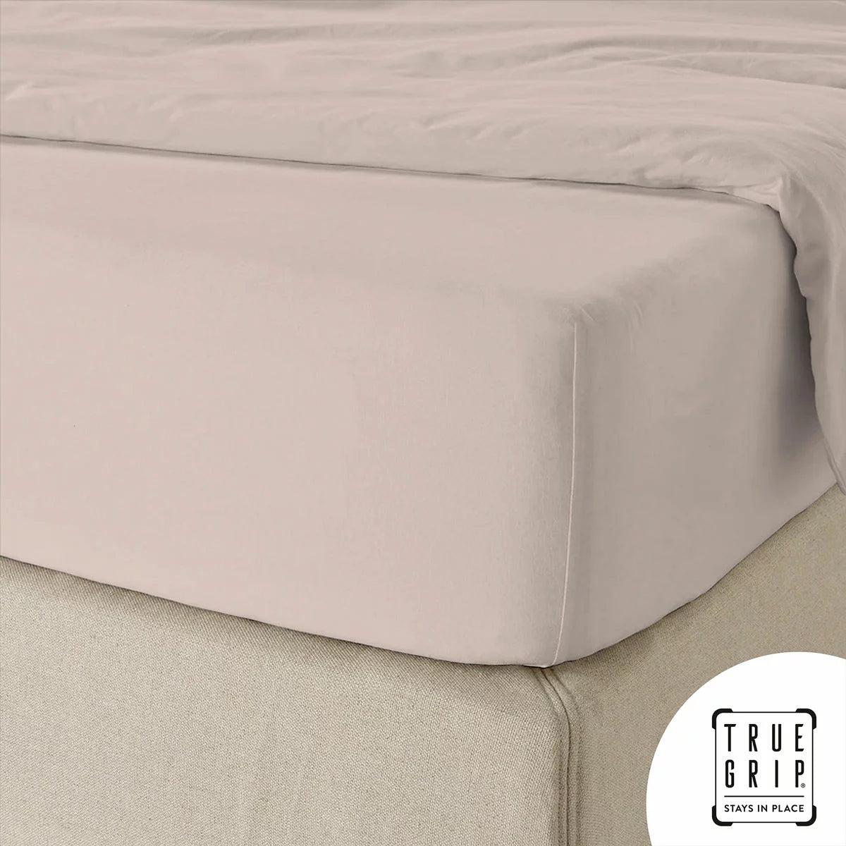 A single pink cotton sateen fitted sheet tightly secured over a thick mattress corner, demonstrating the snug fit of the True Grip elasticated base.