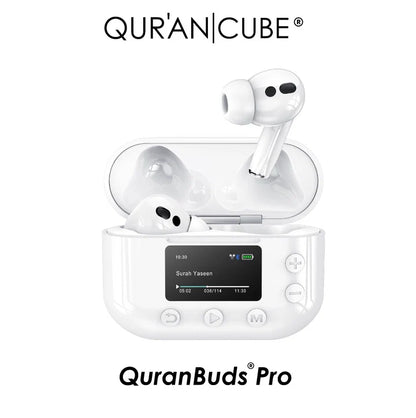 Pair of white Quran Buds Pro wireless earbuds positioned next to their sleek digital display charging case on a dark surface.