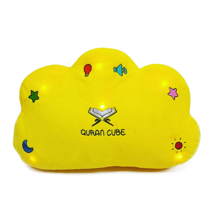 Soft yellow plush Quran Cube Dua Pillow showing stitched colorful button icons for Surahs and duas resting on a white bed sheet.