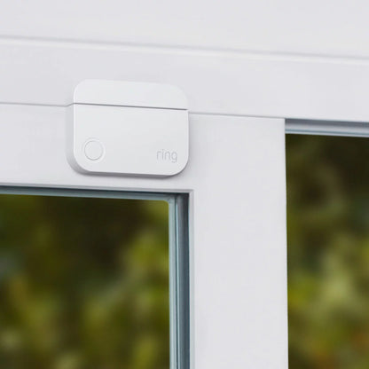 Ring 15 Piece Alarm 2nd Gen Starter Kit in sleek white showing the base station, keypad, outdoor siren, indoor camera, battery video doorbell, sensors, and motion detectors arranged neatly on a modern light backdrop.