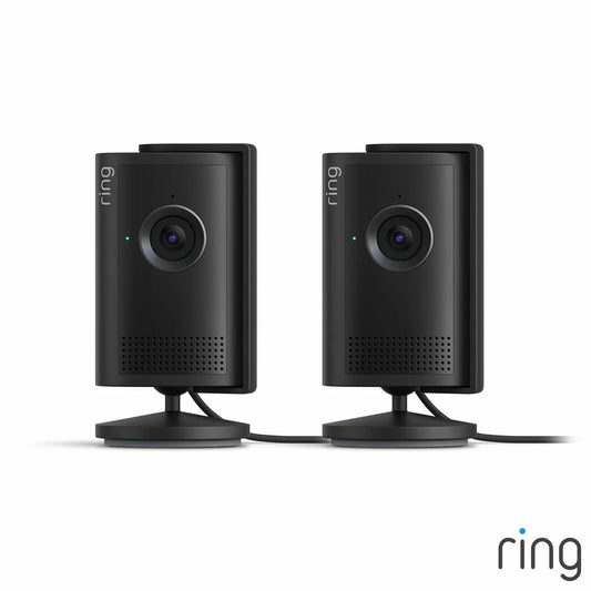 Pair of sleek black Ring Plug-In Indoor Camera Plus units standing side by side on flexible swivel bases against a neutral interior background.