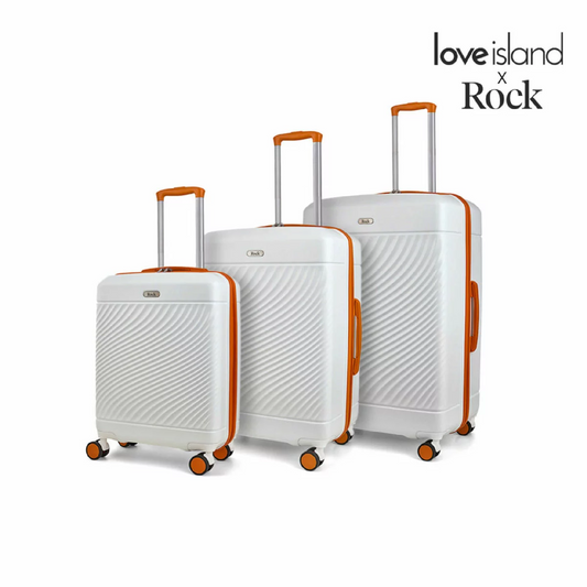 Front view of the Rock Love Island 3 piece hardside luggage set in glossy candy pink showing cabin, medium, and large suitcases lined up in a bright hotel lobby.