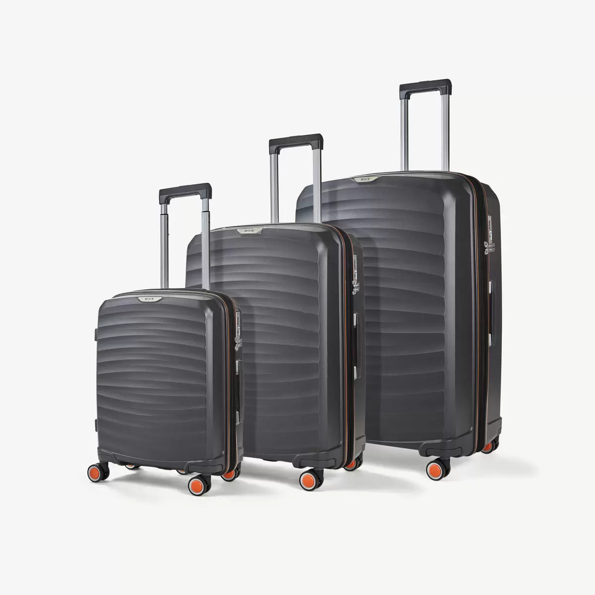 Three-quarter angle of three ocean-blue Rock Sunwave hardside suitcases stacked in cabin, medium, and large sizes on a glossy terminal floor.
