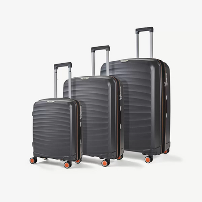 Three-quarter angle of three ocean-blue Rock Sunwave hardside suitcases stacked in cabin, medium, and large sizes on a glossy terminal floor.
