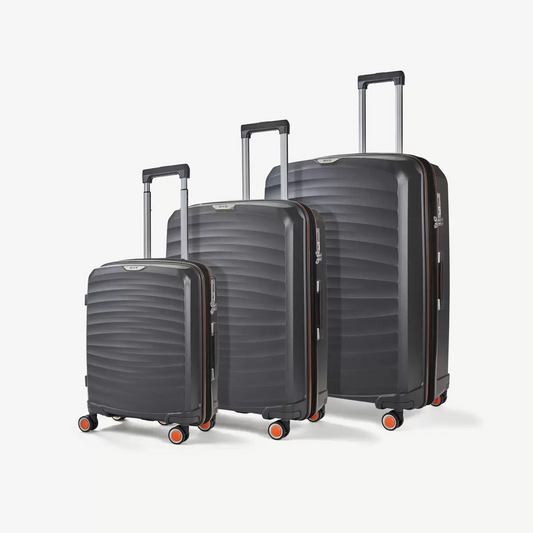 Three-quarter angle of three ocean-blue Rock Sunwave hardside suitcases stacked in cabin, medium, and large sizes on a glossy terminal floor.