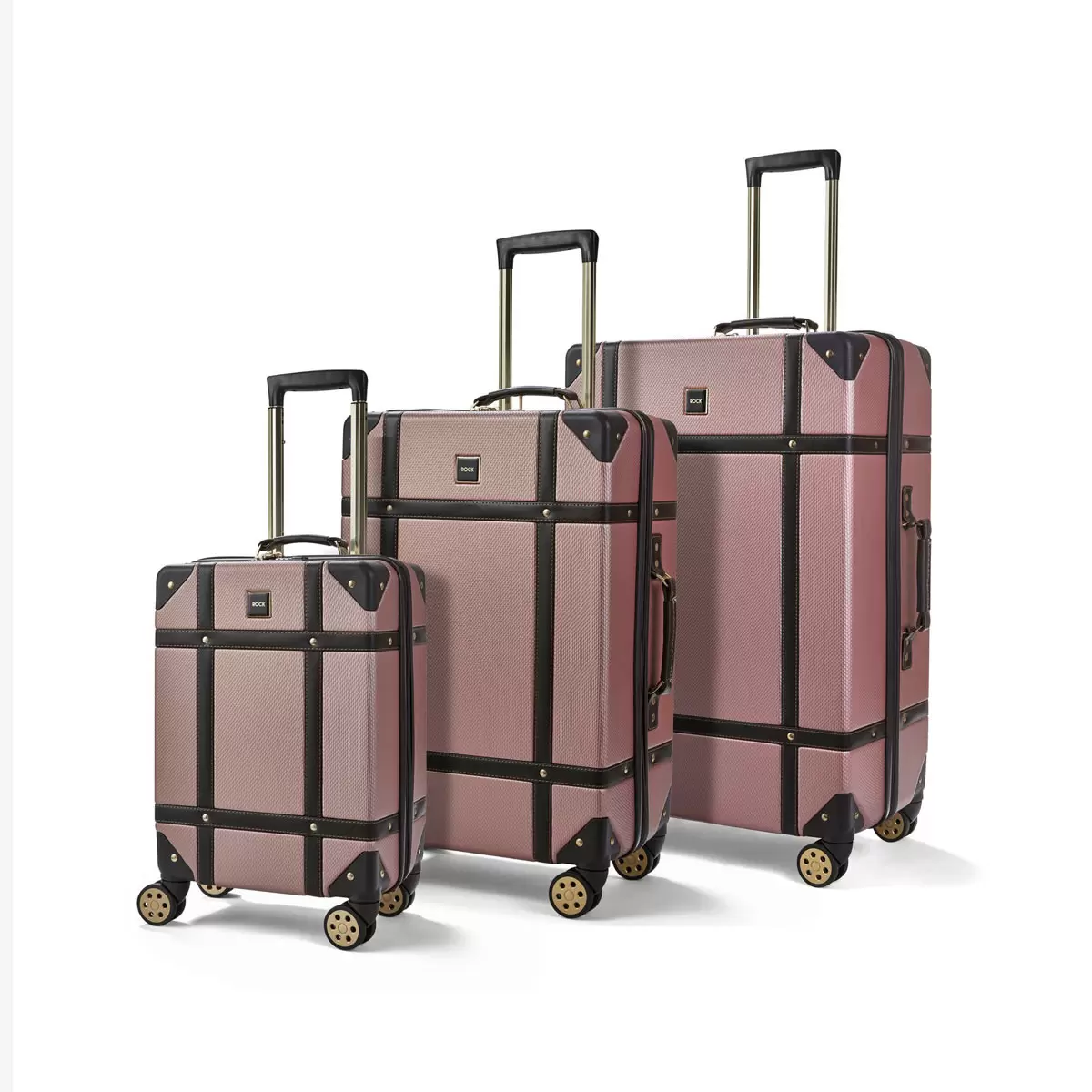 Front three-quarter view of the three-piece Rock Vintage hardside luggage set in three sizes standing on airport tile.