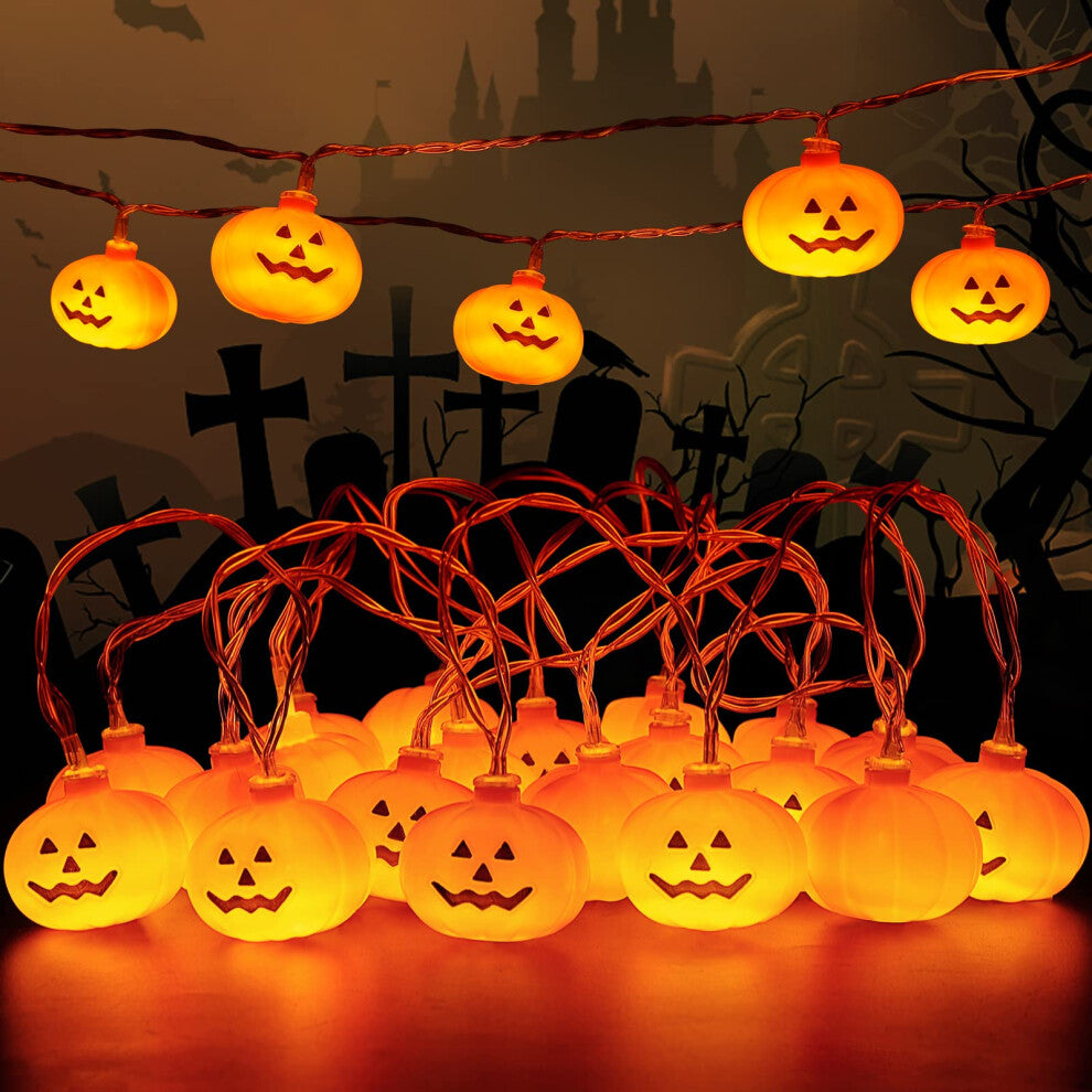 A 3-meter string of 20 mini pumpkin LED lights glowing warmly on an outdoor garden patio wooden fence.