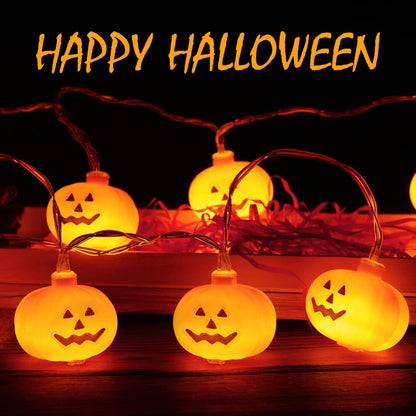 A 3-meter string of 20 mini pumpkin LED lights glowing warmly on an outdoor garden patio wooden fence.