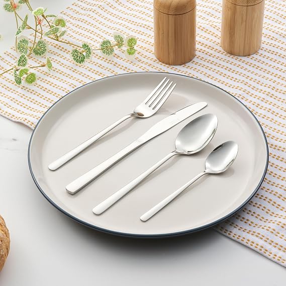 Top-down view of the 48-piece Russell Hobbs Vienna stainless steel cutlery set with a mirror polish finish arranged neatly on a wooden dining table.