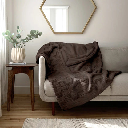 Soft cream Safdie luxury faux rabbit fur throw folded neatly on a grey linen sofa showing off its plush brushed texture.