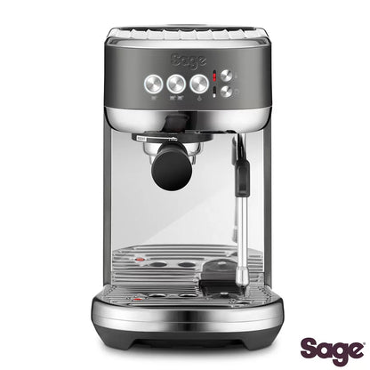 Front view of the compact Sage Bambino Plus espresso machine in sleek matte black stainless steel set on a modern kitchen countertop next to a filled milk jug.