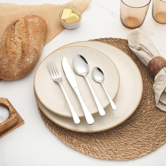 Silver Salter Bakewell 24 piece mirror polished stainless steel cutlery set arranged on a formal dinner table setting.