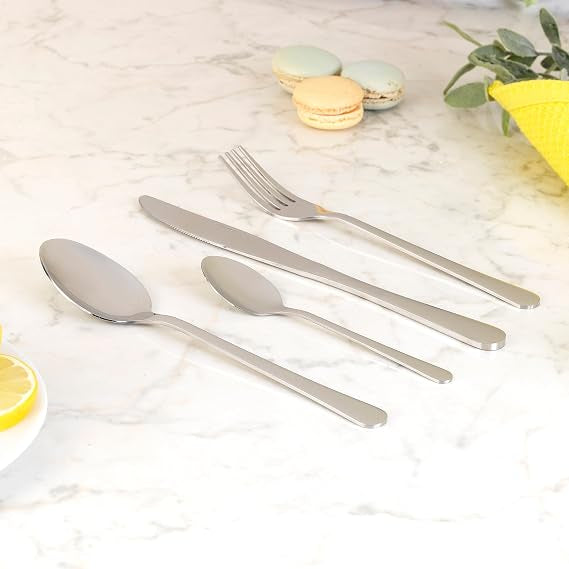 Overhead view of the silver Salter Bakewell 48-piece stainless steel cutlery set arranged neatly on a dark wooden table setting.