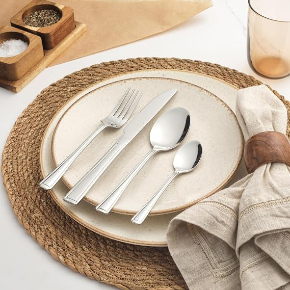 Salter Buxton 16-piece mirror-polished silver stainless steel cutlery set arranged neatly on a dark wooden table setting.