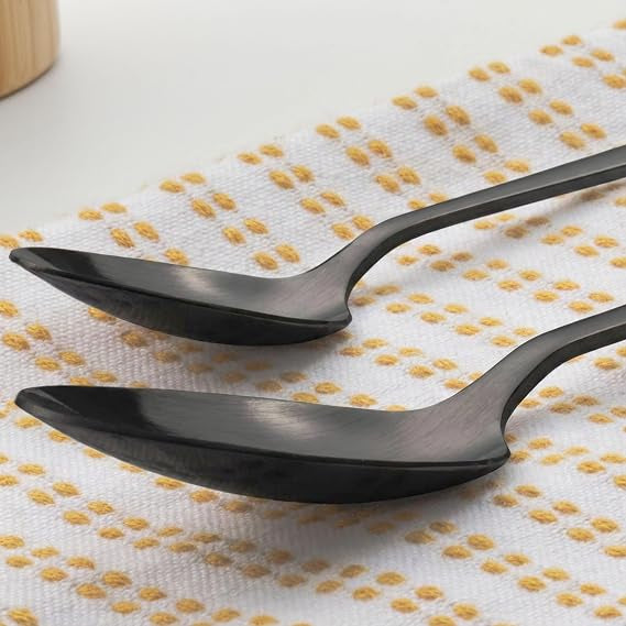 Overhead view of the 16-piece Salter Chiltern cutlery set in brushed matte black stainless steel arranged neatly on a dark slate dining table.